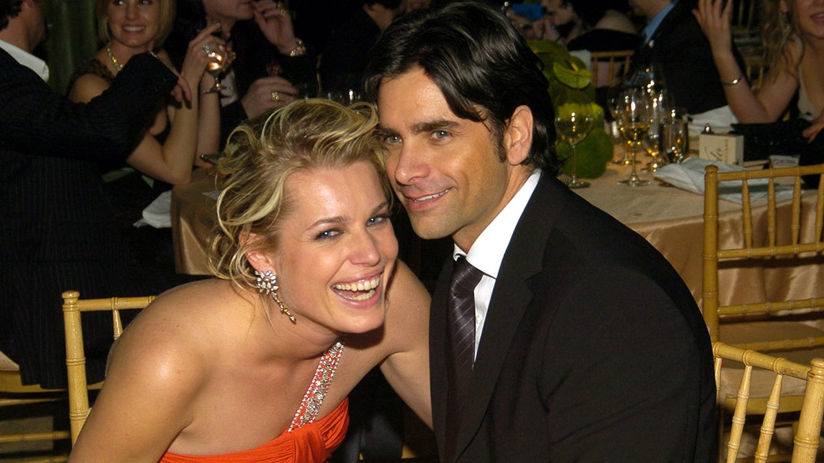 Rebecca Romijn laughs at a Vanity Fair dinner party with John Stamos