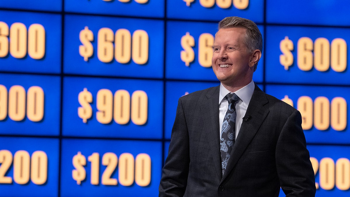 Ken Jennings standing in front of the Jeopardy board
