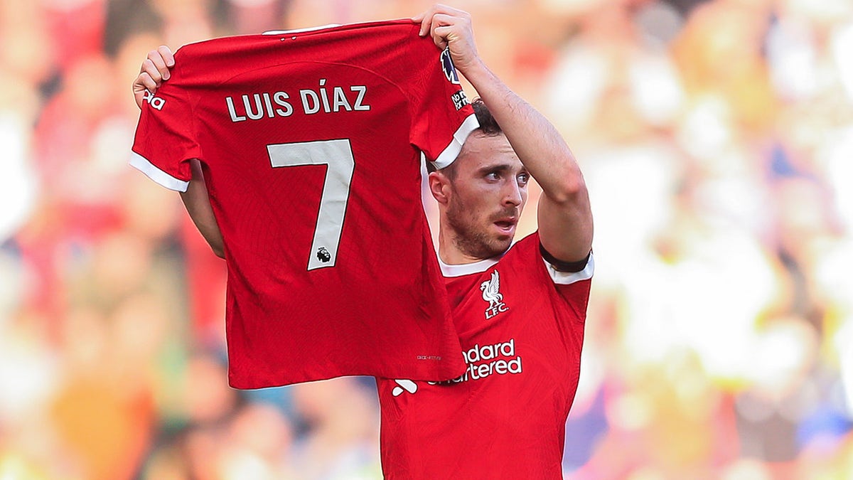 Diogo Jota holds up Diaz's jersey