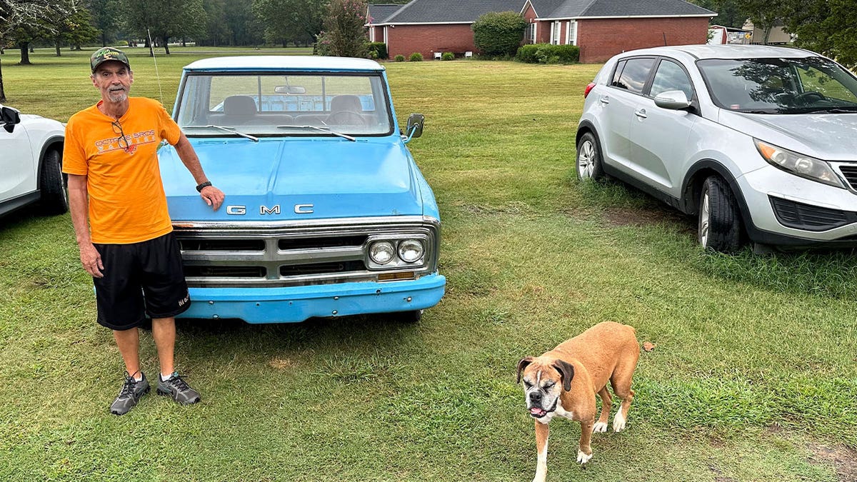 Ricky Dority poses for a photo with his 1969 GMC pickup and his family dog "Boots" outside his family's home in Greenwood, Arkansas, on Sept. 22, 2023. After using pandemic relief funds to hire a private investigator, Dority was able to get his name cleared of murder.