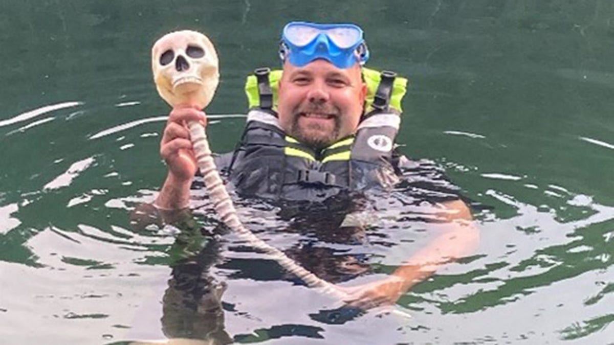 man holding beer bong that looks like a skull