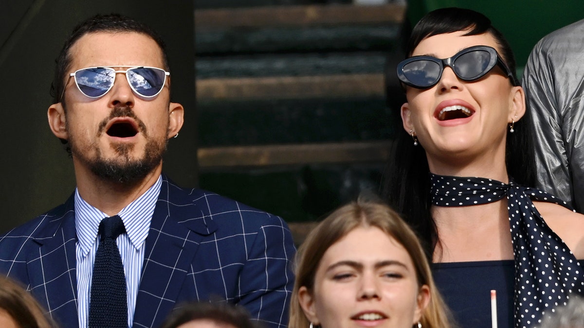 Orlando Bloom in a blue plaid jacket watches Wimbldeon alongside Katy Perry