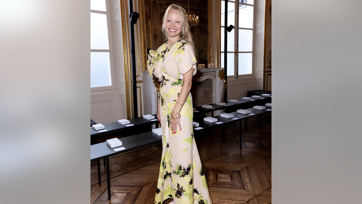 Pamela Anderson in a cream outfit at the Victoria Beckham fashion show in Paris