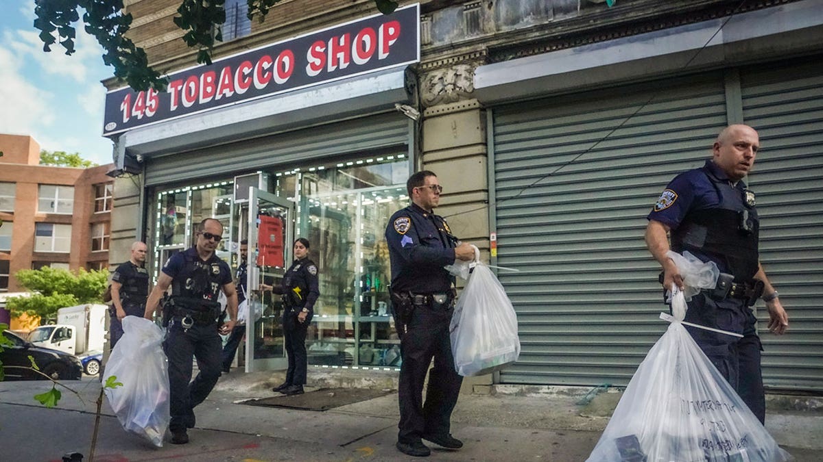 officers carrying bags of vaping products