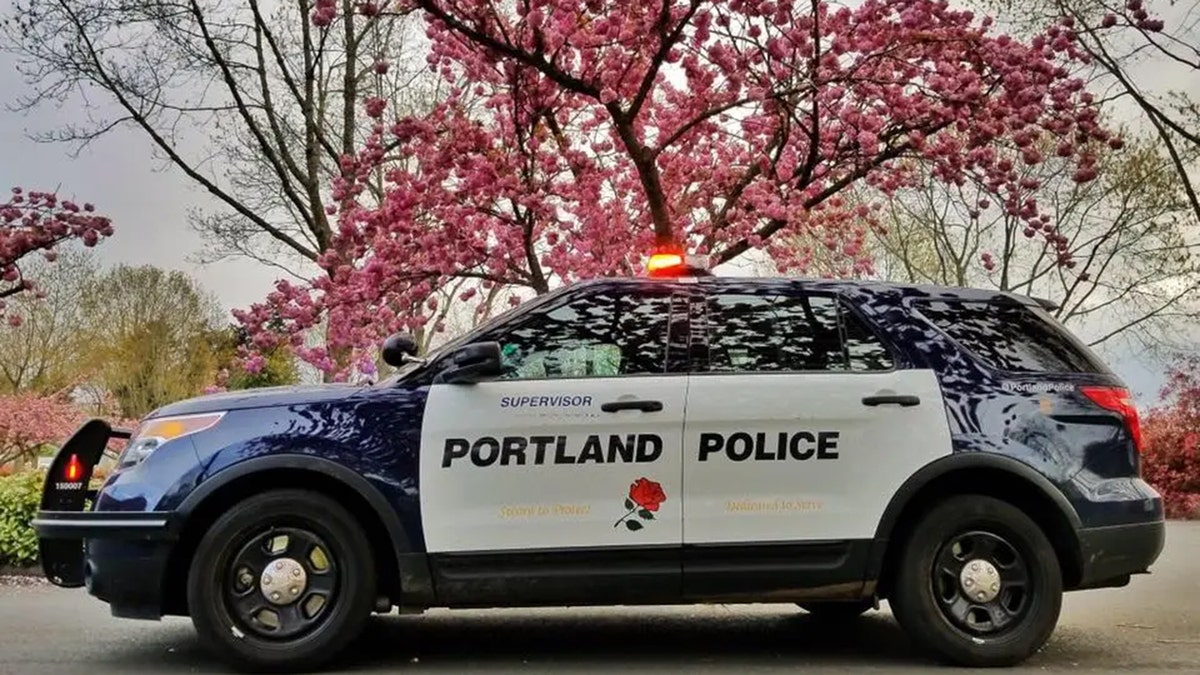 Portland Police Department Cruiser next to trees with blossoms