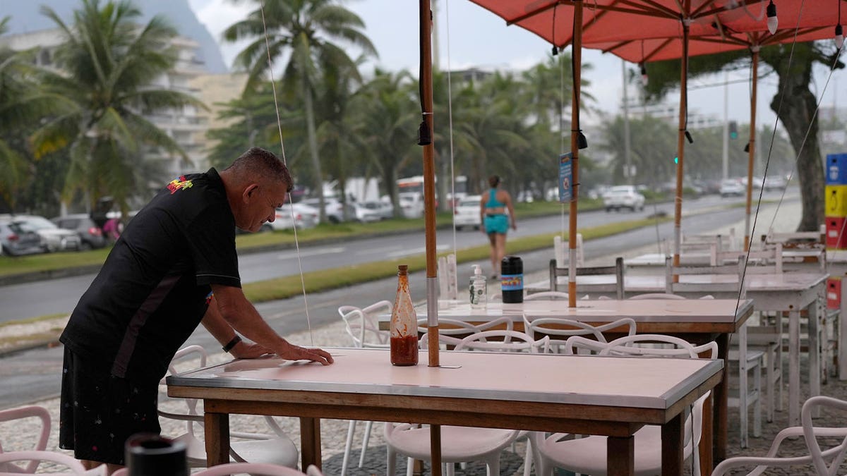 worker looks at table with bullet hole