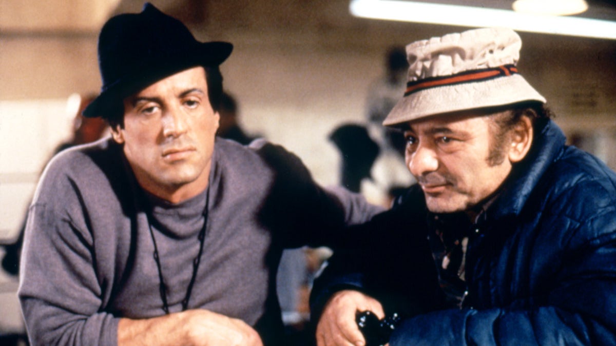 Burt Young and Sylvester Stallone stand ringside in boxing movie Rocky