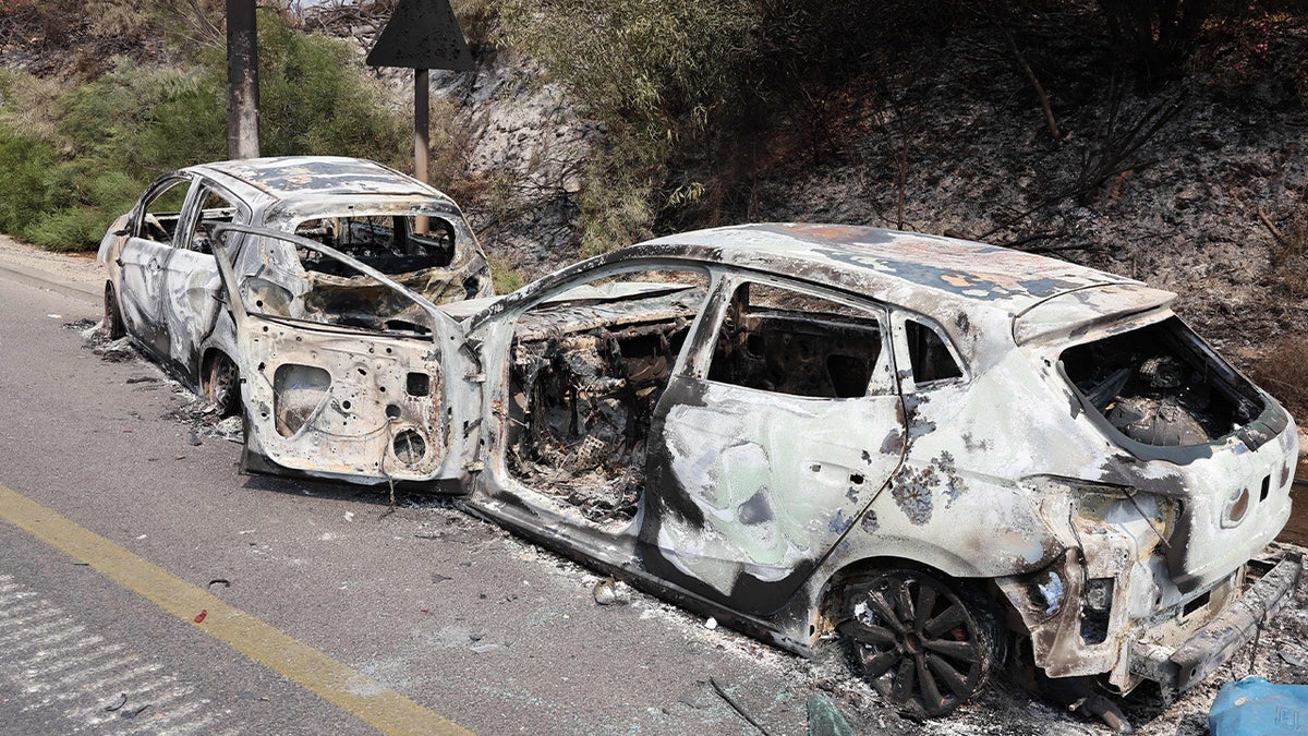 Two burned cars on side of road in Sderot, Israel