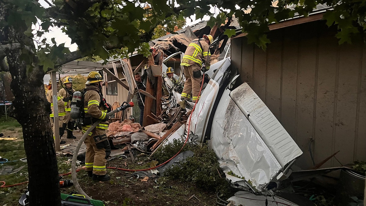 firefighters and plane wreckage in home