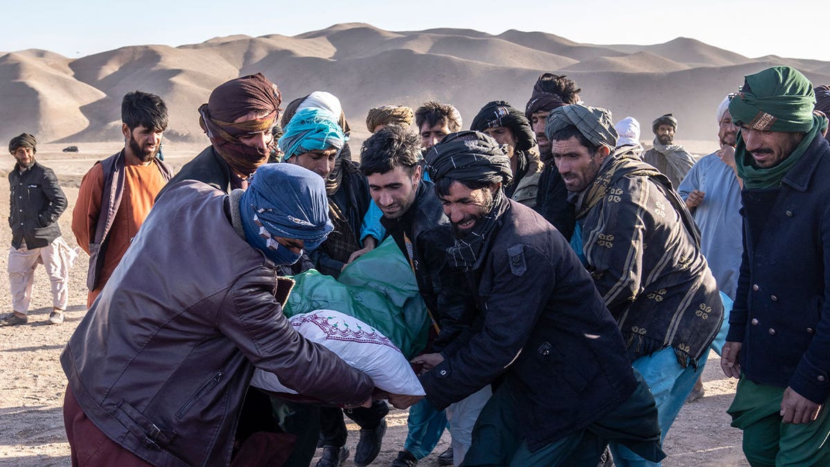 Afghans carrying a body following earthquake