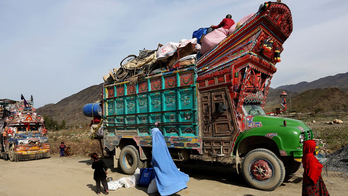 Afghans near truck full of belongings