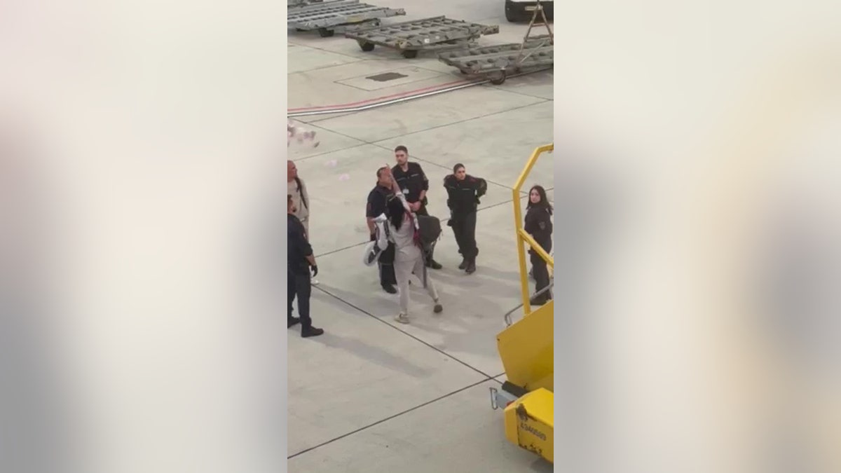 airport drama in Vienna as woman throws cash at partner