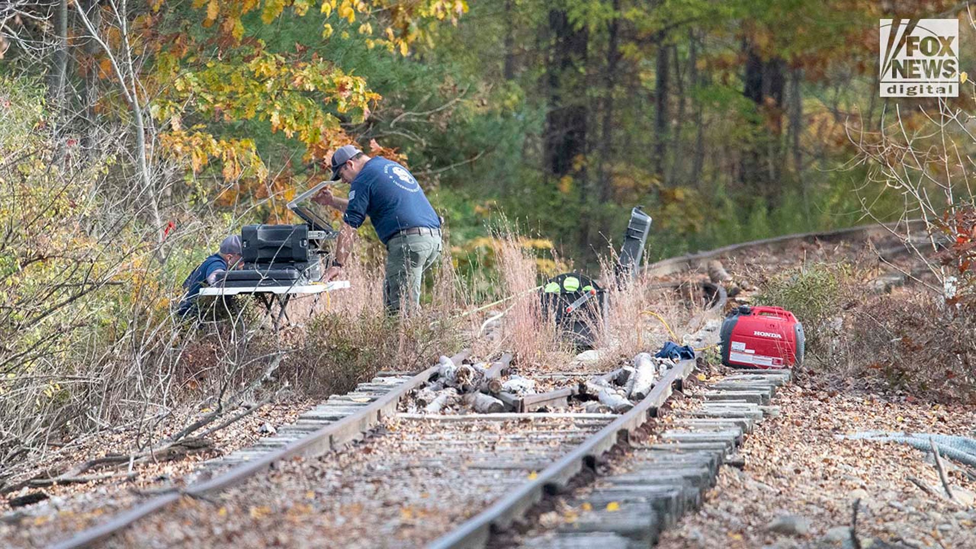 Law enforcement agents aid in the search for Robert Card along nearby railroad tracks by the Androscoggin River