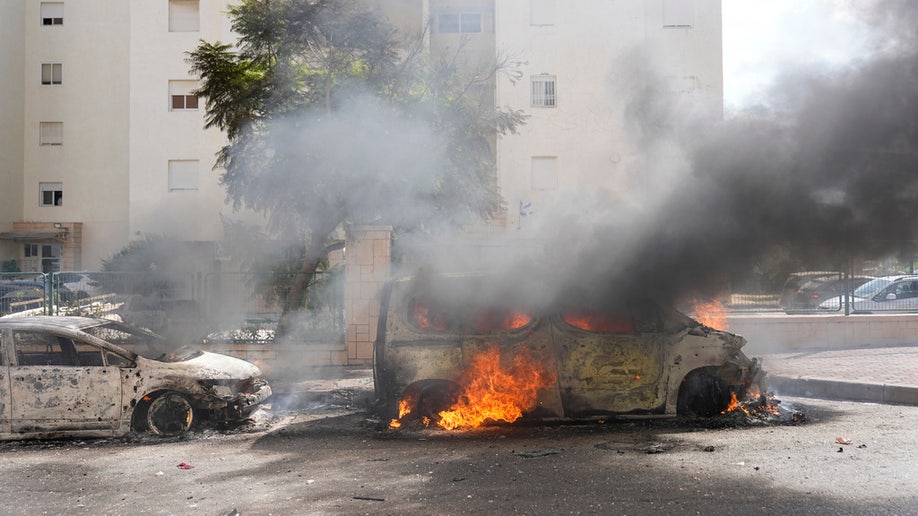 Car on fire in street at the Gaza Strip