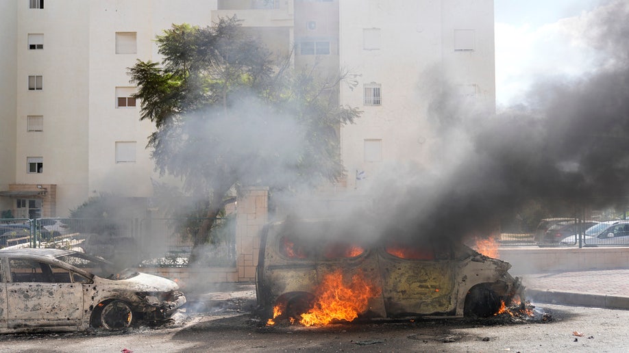 Car on fire in street at the Gaza Strip