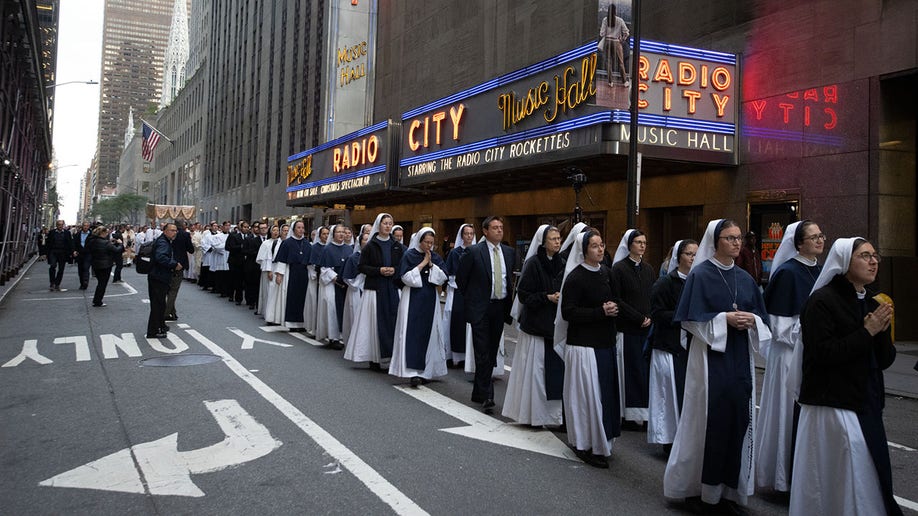 Catholic nuns make a procession past Radio City Music Hall