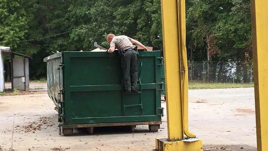 A member of the FBI's CARD team searches a dumpster for six-year-old Maddox Ritch.
