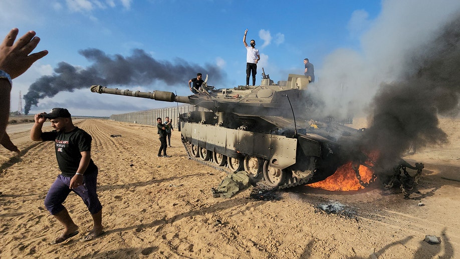 Palestinians celebrate amid wreckage of Israeli tank