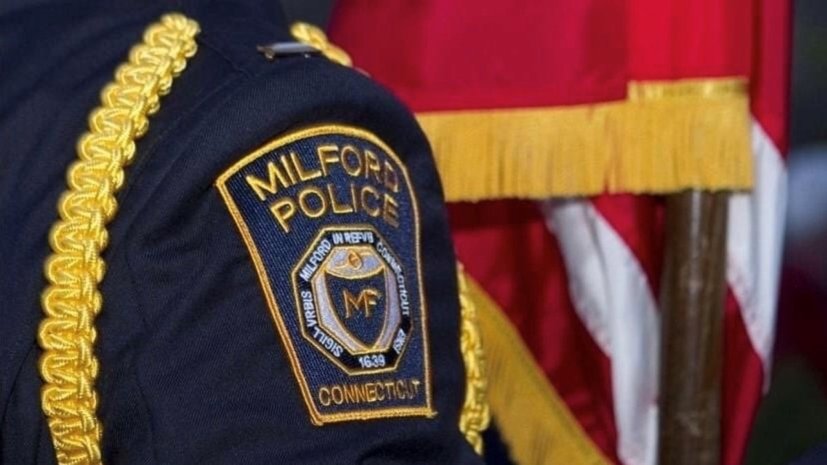 A Milford Police Department badge on an officer's uniform