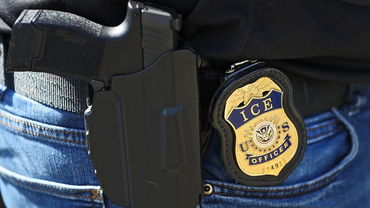 ICE officer badge with handgun