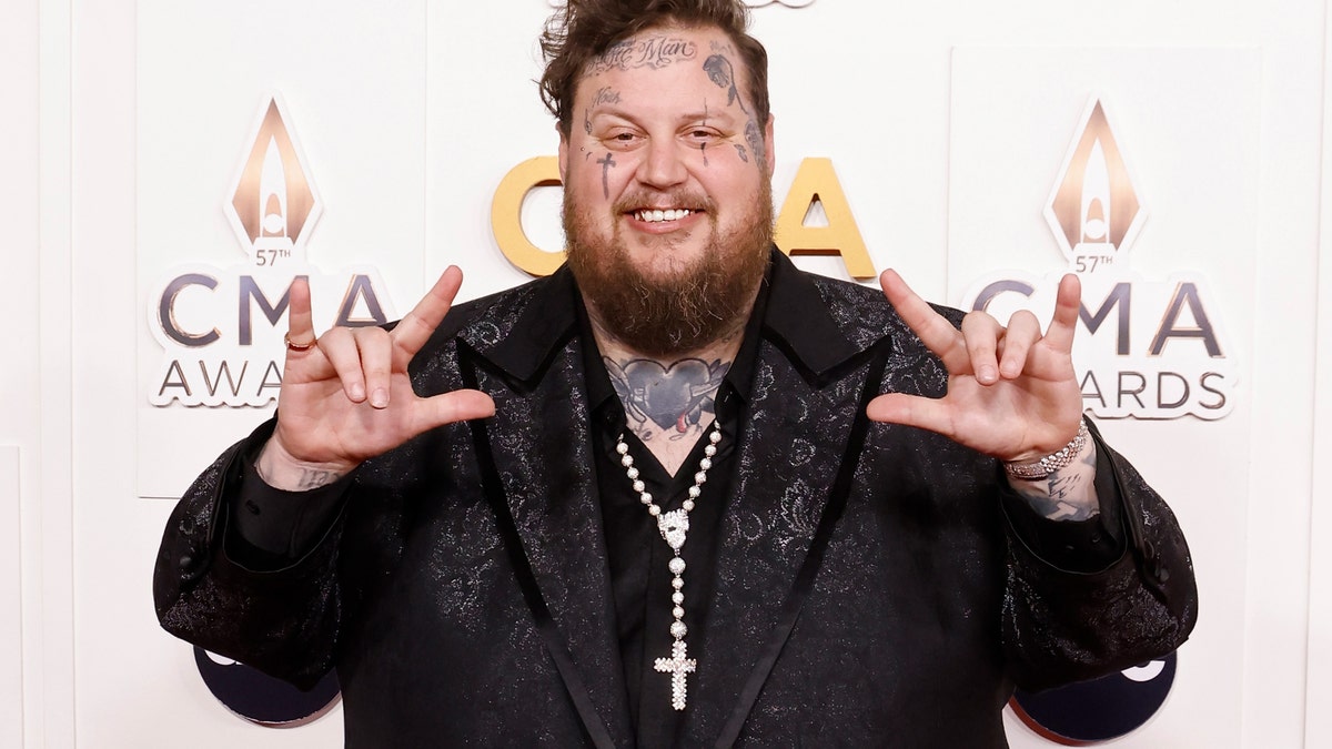 Jelly Roll puts up 'I love you' in sign language on the CMA Awards carpet