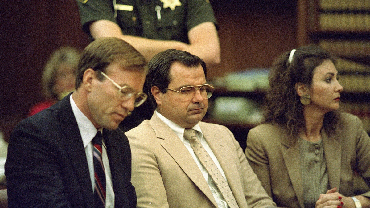 Craig Allen Peyer wearing a beige suit in between two attorneys in court