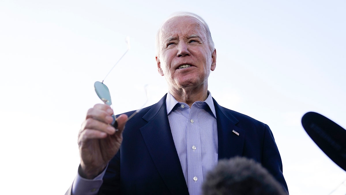 Joe Biden con gafas de sol en la mano