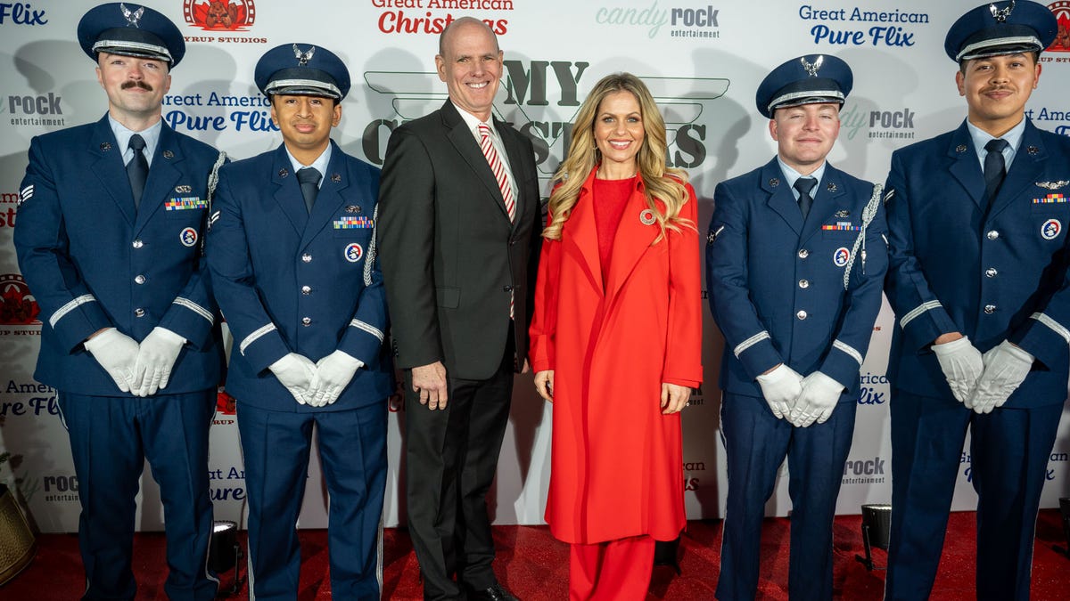 Bill Abbott and Candace Cameron Bure posing with members of the military