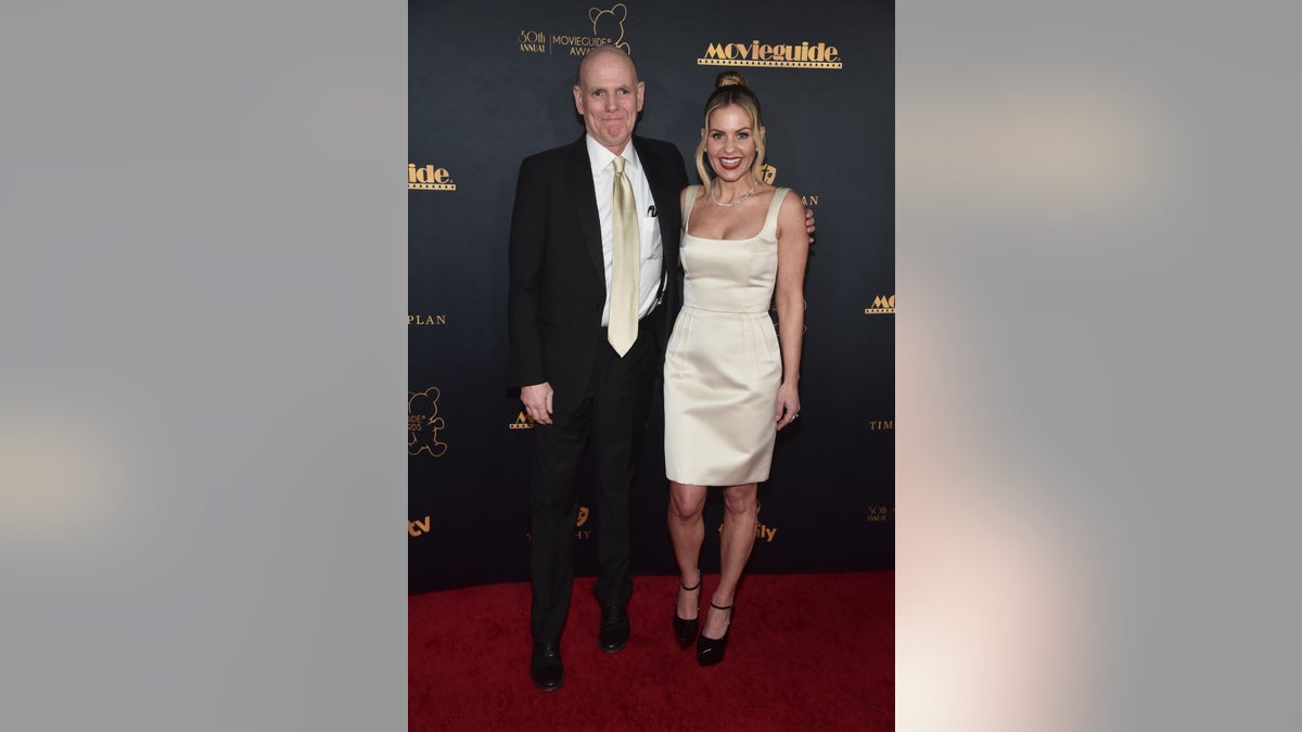 Candace Cameron Bure and Bill Abbot posing together on the red carpet