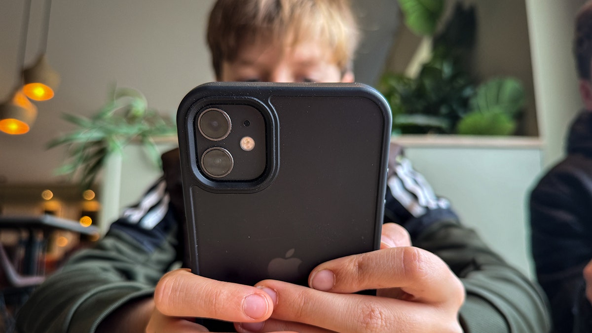 Boy looks at an iPhone