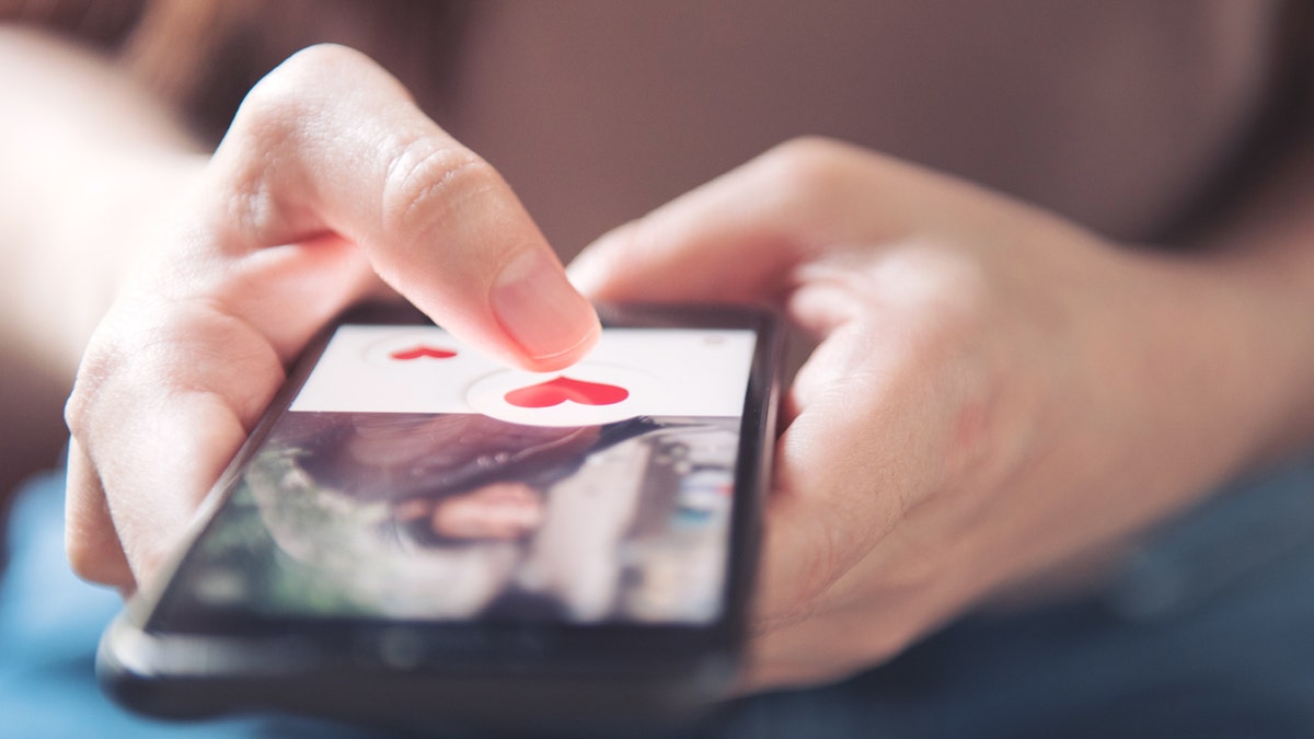 A person using a dating app on a cell phone