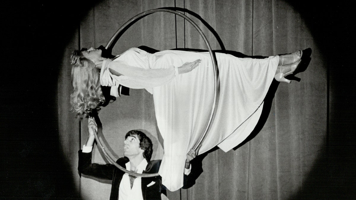 David Copperfield performing a levitation trick with a female assistant