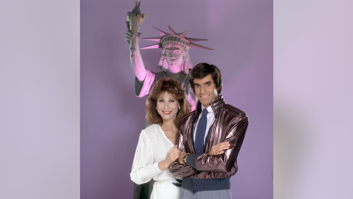 David Copperfield posing in front of Statue of Liberty model with Michelle Lee