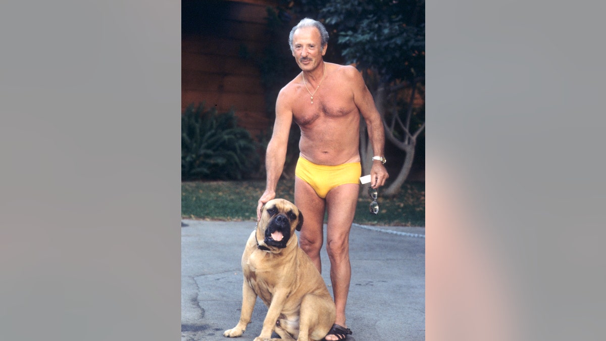 Frank Stallone posing in a speedo with a dog