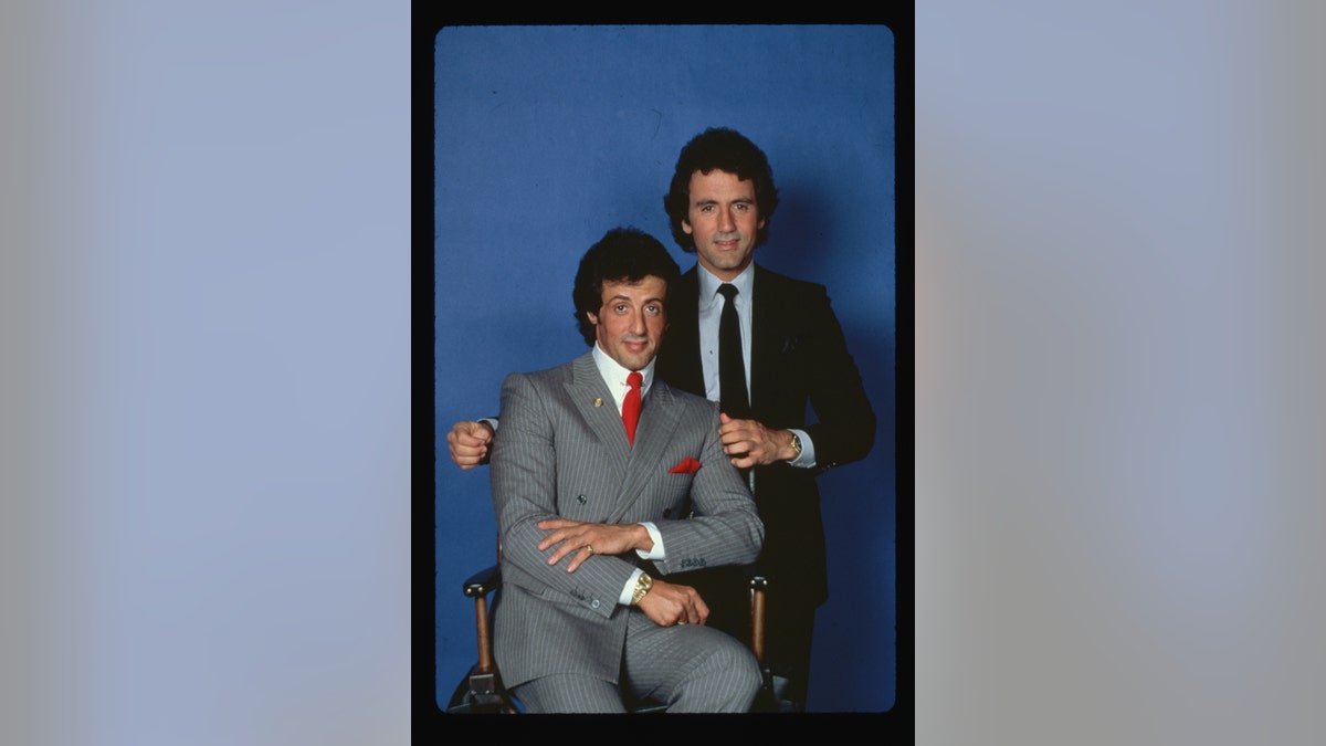 Sylvester Stallone seated with brother Frank Stallone Jr.