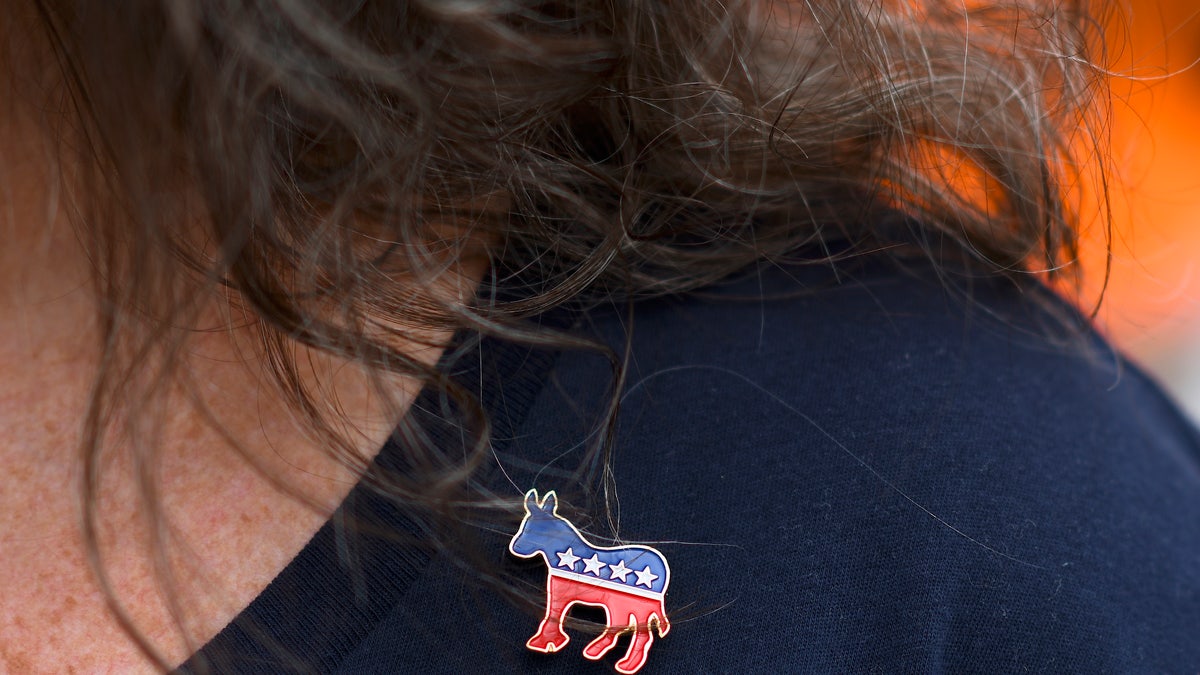 A woman wears a Democratic pin