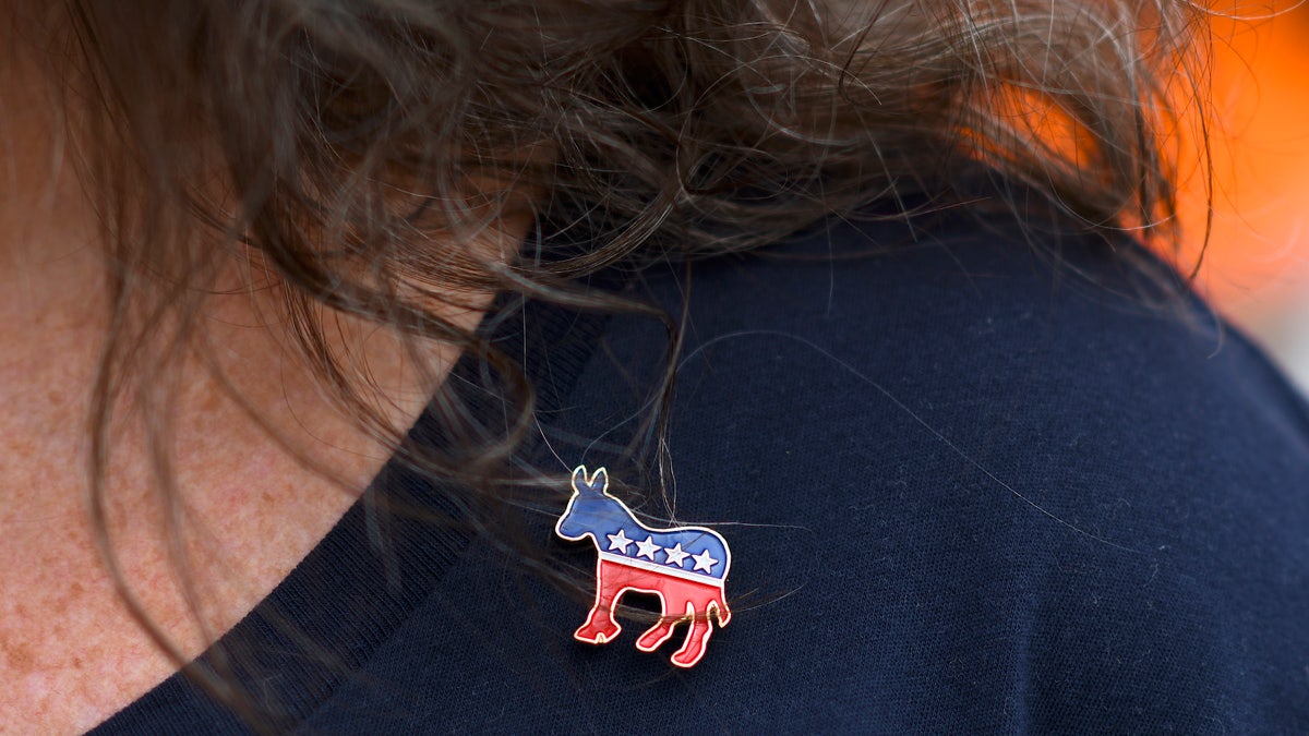 A woman wears a Democratic pin