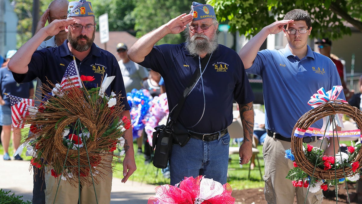 FILE-- Members of American Legion Post 40 salute after placing a wreath during the annual Memorial Day service at Memorial Park. Community organizations and military veterans take part in the annual Memorial Day parade and service. 