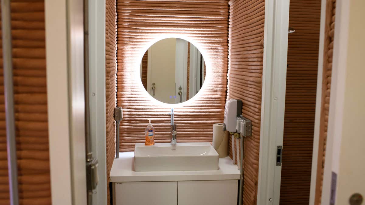 Bathroom of the CHAPEA Mars dwelling features a hanging mirror and white sink