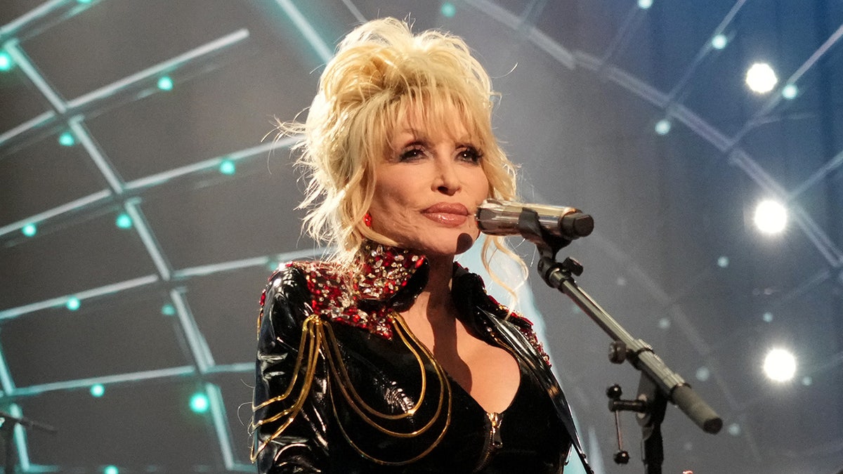 Dolly Parton on stage in front of microphone