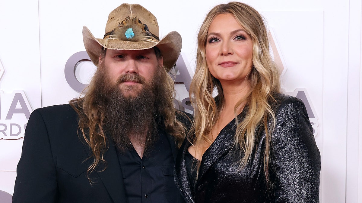 Chris Stapleton poses on the carpet with wife Morgane, both dressed in black
