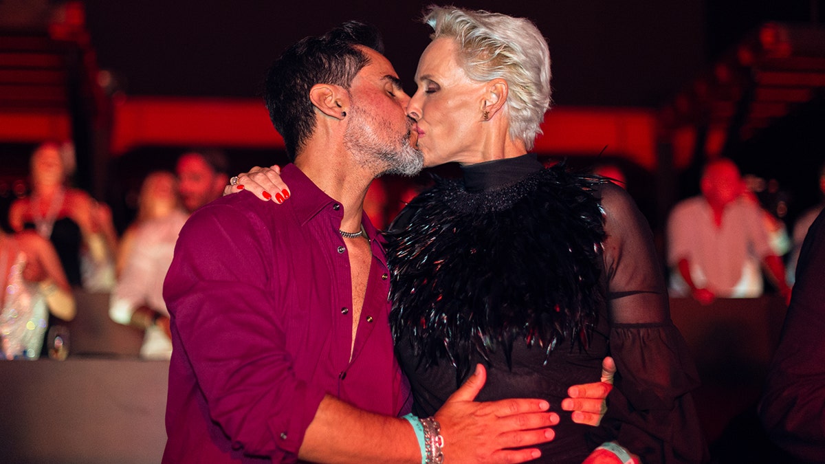 Brigitte Nielsen in a black dresses kisses her husband Mattia Dessi in a magenta shirt