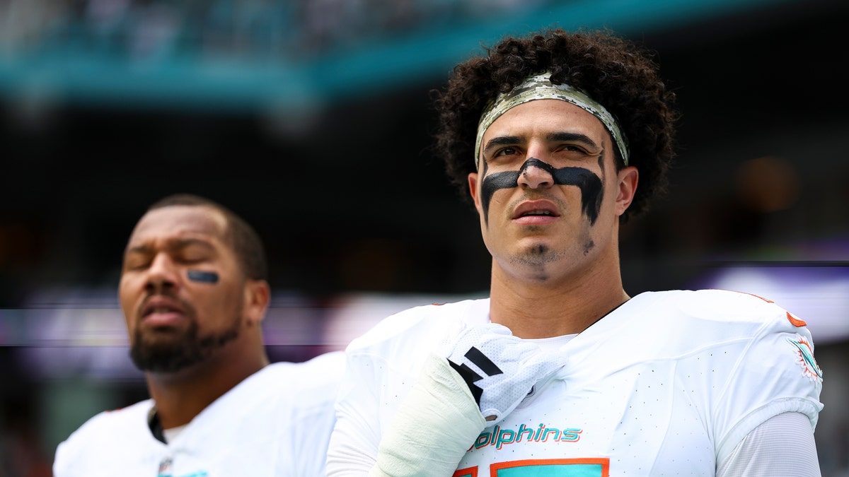 Jaelan Phillips stands on the sidelines during a Dolphins game
