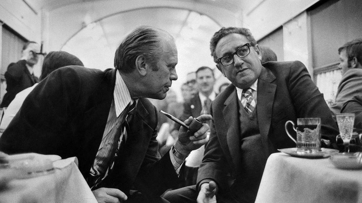 Former US President Gerald Ford talks with Henry Kissinger