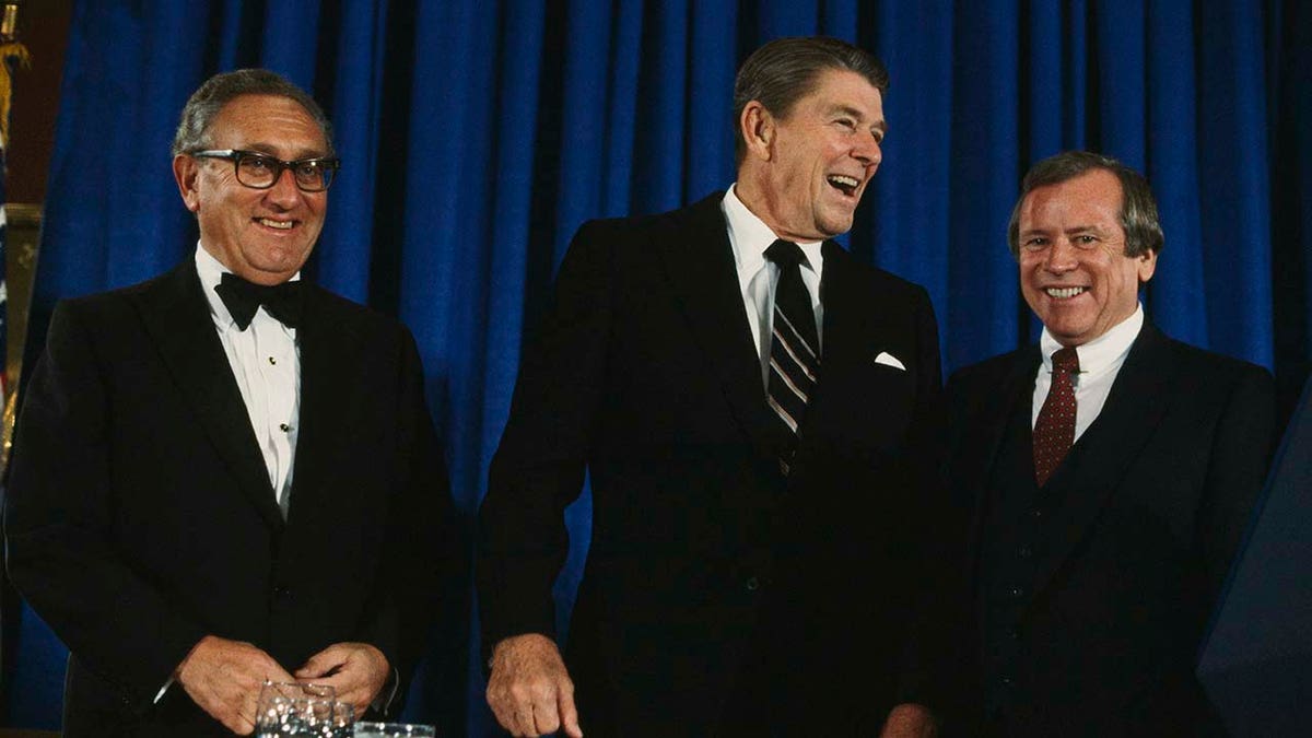 Former President Ronald Reagan and Henry Kissinger seen standing together