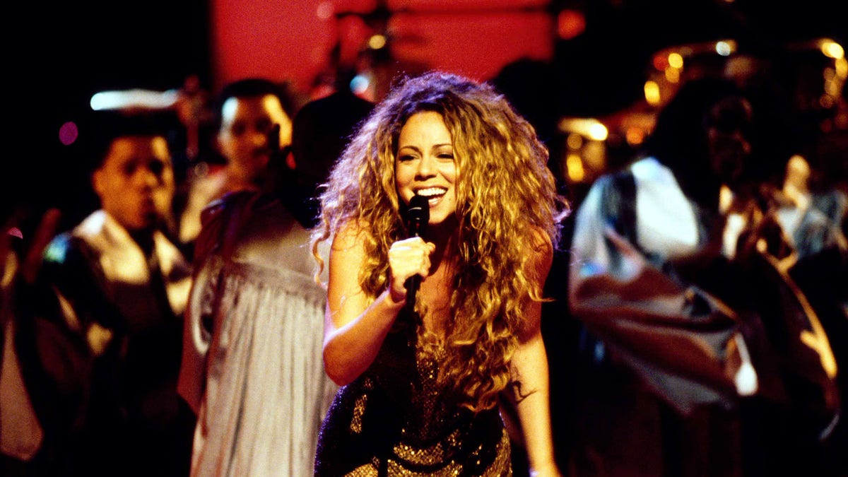 Mariah Carey holds a mic
