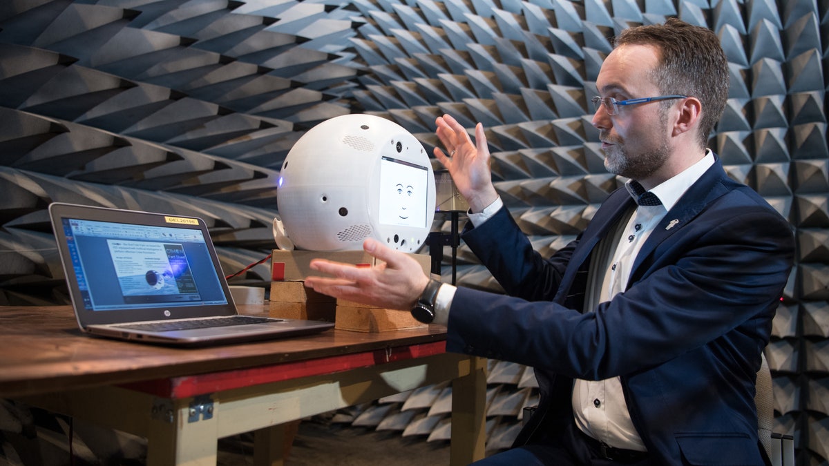 Scientists hold CIMON, the artificial intelligence space companion, in a laboratory on Earth