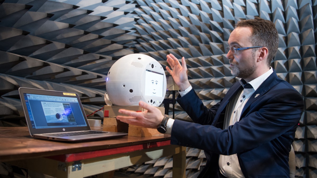 Scientist holds CIMON the artificial intelligence space companion in Earth lab