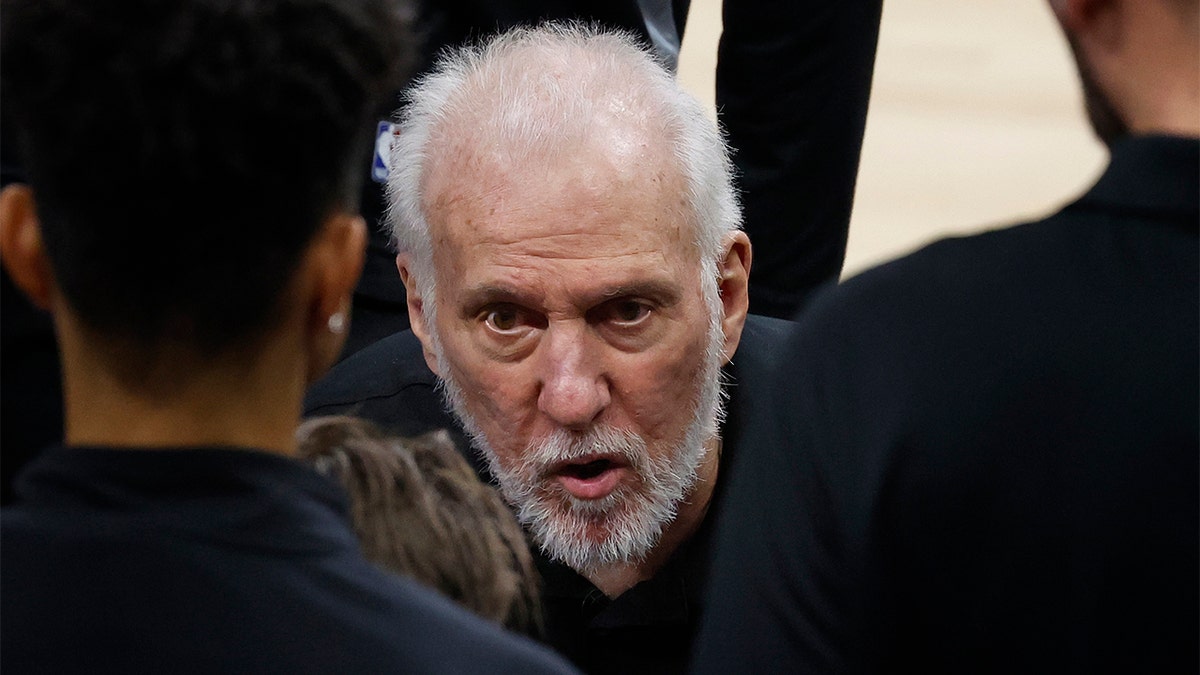 Gregg Popovich speaks with his team