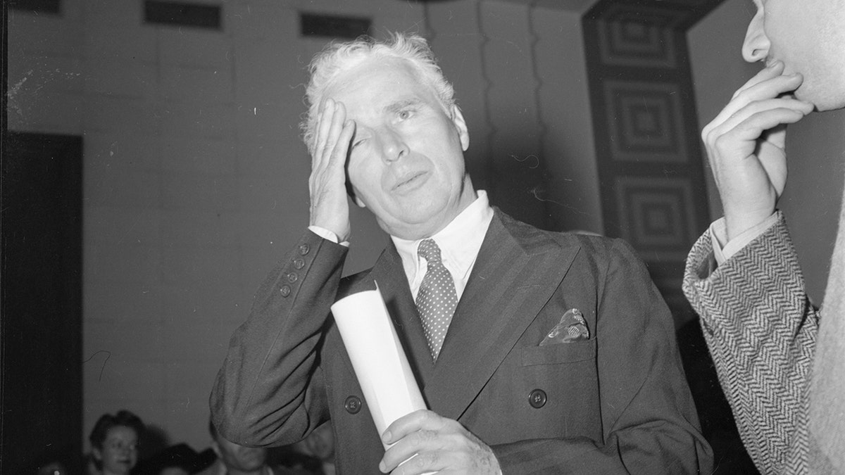 Charlie Chaplin wiping his brow in court